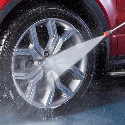 Car wheel being cleaned with a high-pressure water hose
