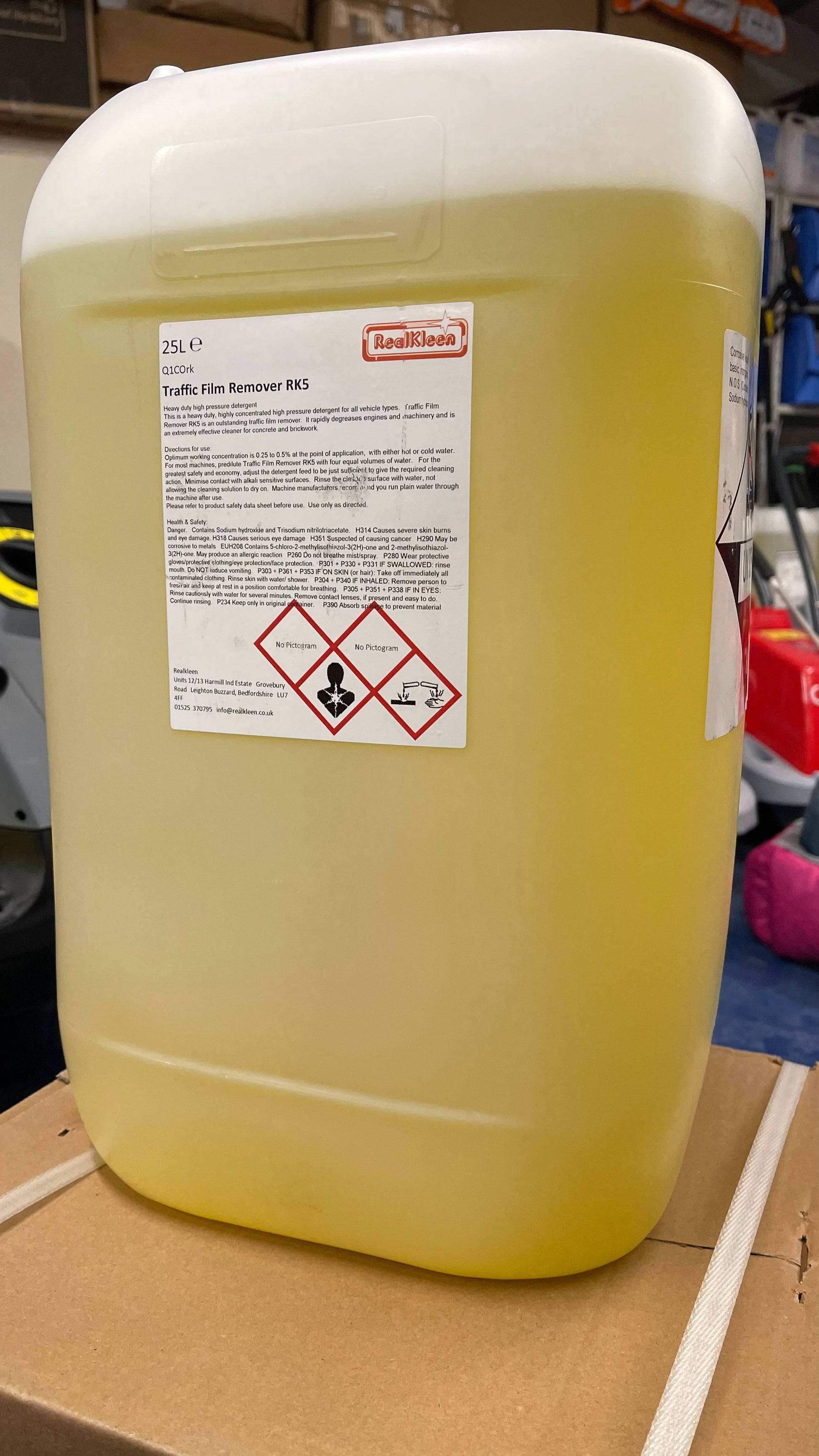Large yellow container with a label on a cardboard surface