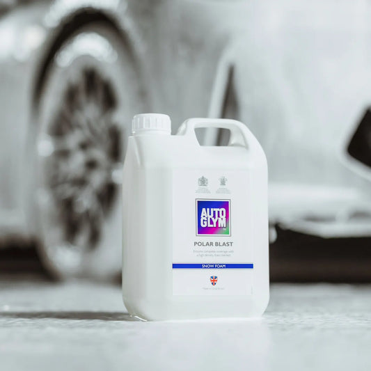 White car care product container with 'Autoglym' branding in front of a blurred car.