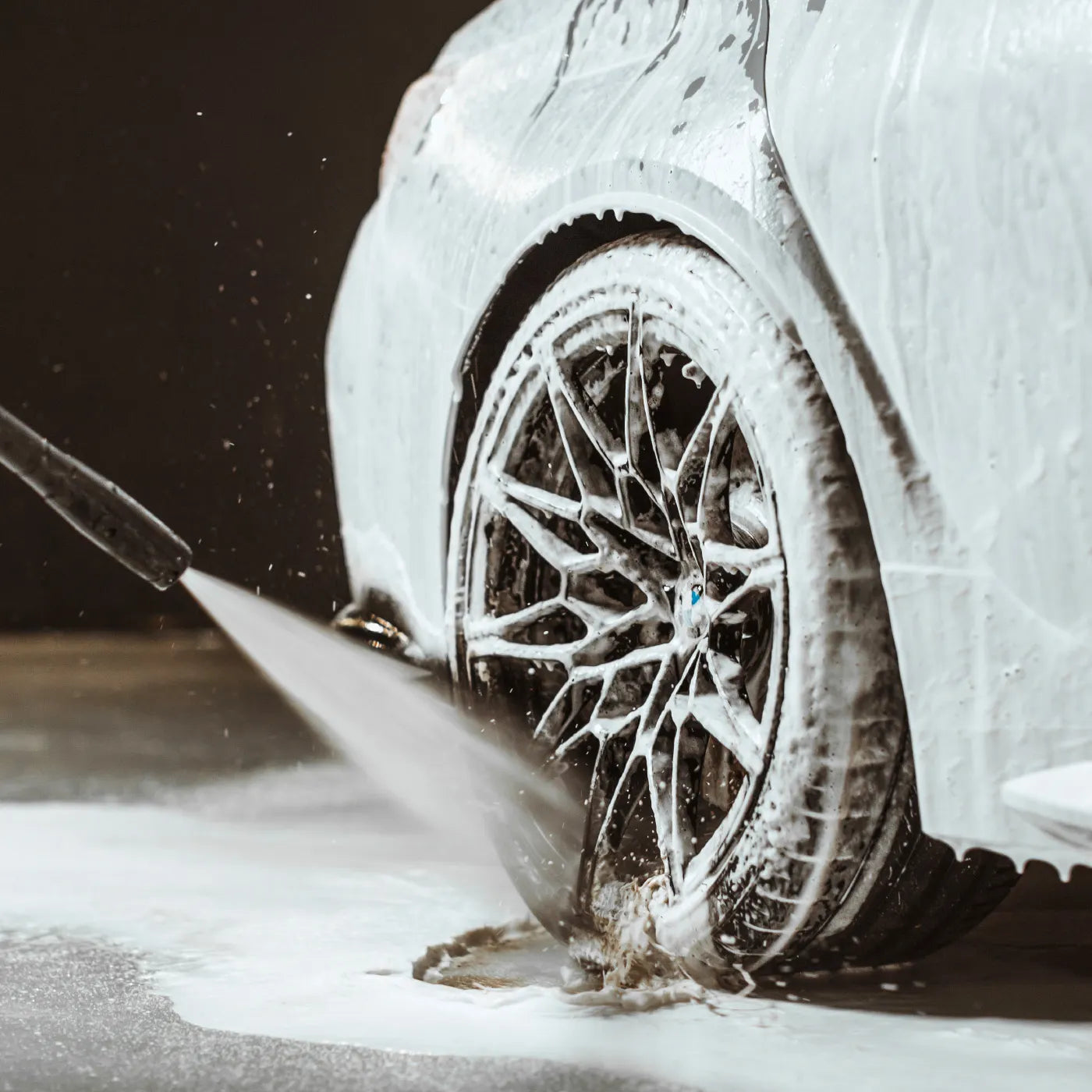 Car tire being cleared of snow with a brush on a snowy road