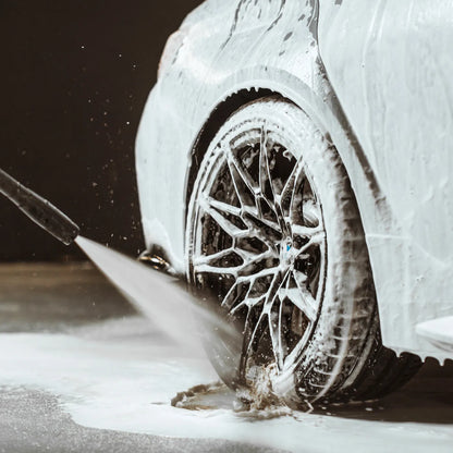 Car tire being cleared of snow with a brush on a snowy road