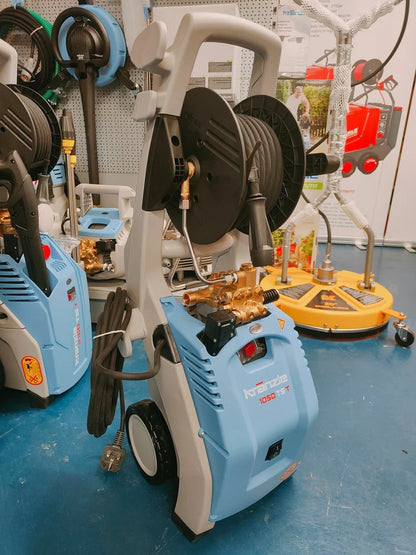 Blue pressure washer with a hose reel on a blue floor, surrounded by other equipment.