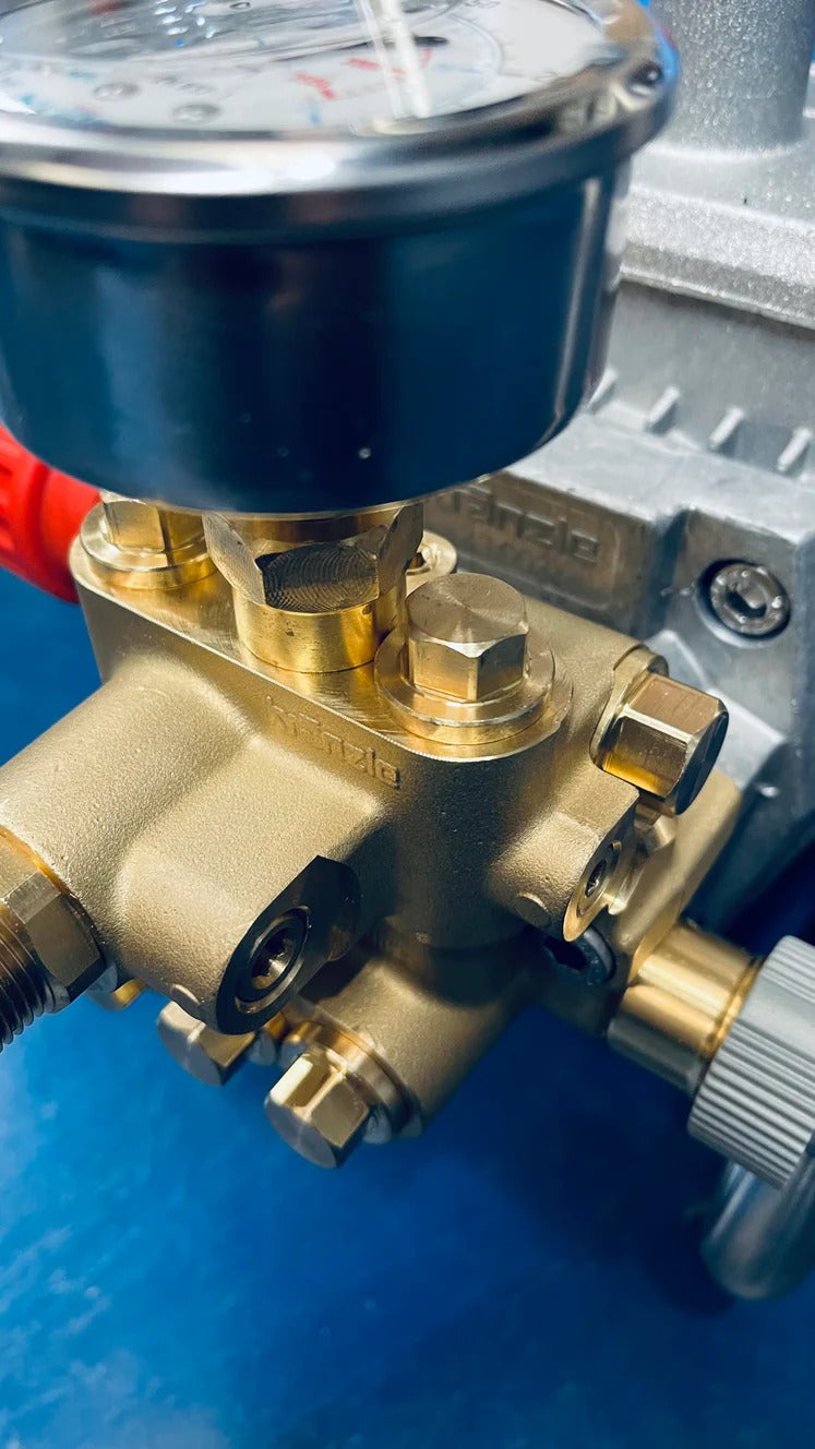 Close-up of a brass pressure gauge with visible brand name on a blue background