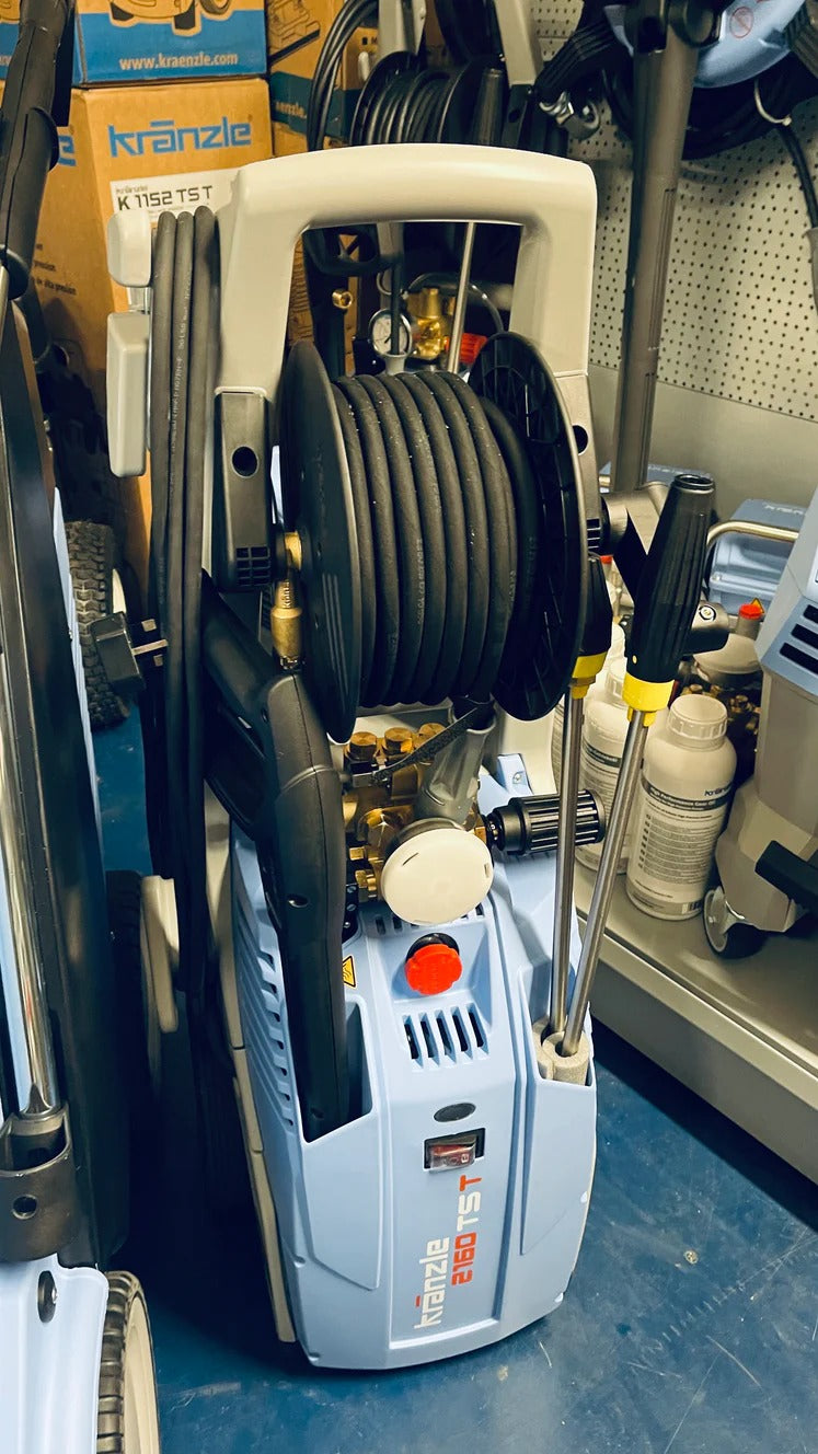 Pressure washer in a garage setting with tools and equipment around