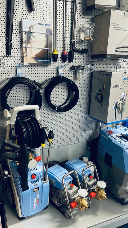 Display of pressure washers and accessories on a pegboard wall.